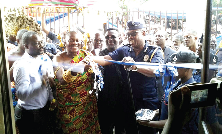 Nana Otuo Siriboe II (2nd left) being assisted by COP Mr Kofi Boakye and other dignitaries to cut the tape to inaugurate the building (inset)